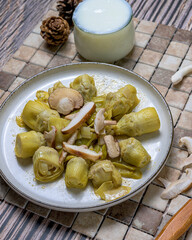 Plate of cooked artichokes with fresh mushrooms served on a rustic background, perfect for healthy cooking and autumn cuisine