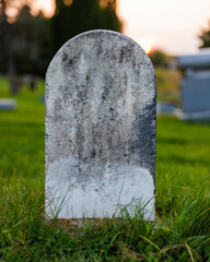 Old marble headstone in a graveyard with biological growth