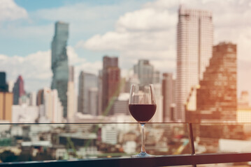 red wine on terrace with Bangkok city skyline at sunset, cocktail on rooftop, vibrant cityscape and...