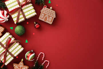 Naklejka na ściany i meble Christmas flat lay with gift boxes, gingerbread cookie, candy cane and bauble on red background. Holiday composition with copy space for seasonal design Naklejka na ściany i meble Christmas flat lay with gift boxes, gingerbread cookie, candy cane and bauble on red background. Holiday composition with copy space for seasonal design