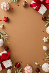 Xmas flat lay with gift boxes, red and white baubles, golden stars, pine branches, and confetti on...