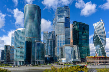 Obraz premium Modern skyscrapers reach for the sky in a vibrant urban landscape under a clear blue sky