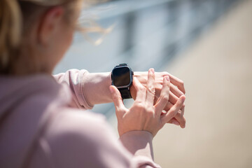Woman checking smartwatch during outdoor fitness workout