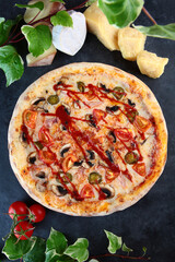Mexican pizza with jalapeno peppers with cheese and tomatoes. Dark background. Top view.
