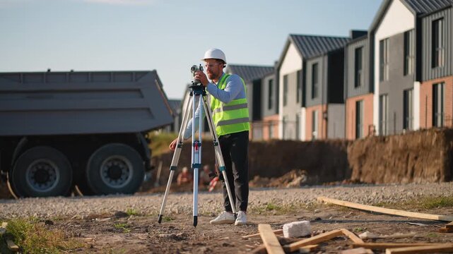 Surveyor engineer using theodolite level on construction site
