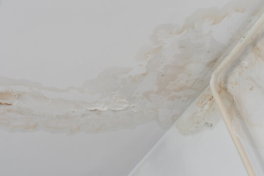 Water stain on white ceiling. Symbol of home maintenance and neglect consequences.