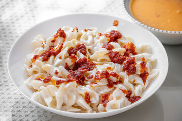yogurt and tomato sauce poured over pasta
