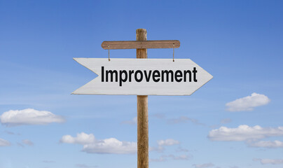 White wooden arrow with the inscription: Improvement