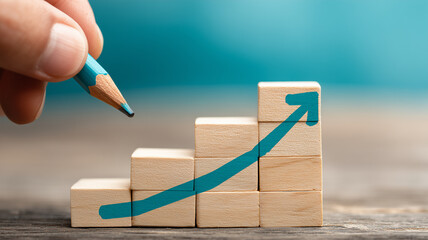 A hand draws an upward arrow across stacked blocks, portraying staged progress measurable growth and focused business strategy
