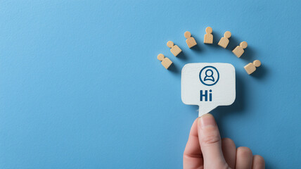 A hand presents a chat bubble that greets a group of people, illustrating communication onboarding customer support and friendly community engagement
