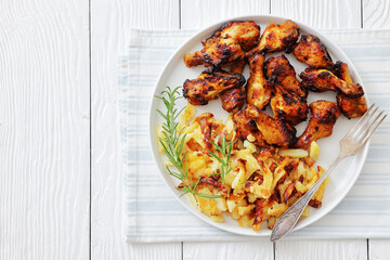 bbq chicken wings with fried potatoes on plate