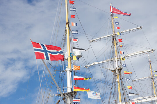 Norwegian flag and colorful international signal flags flying from masts and rigging of tall ship Statsraad Lehmkuhl