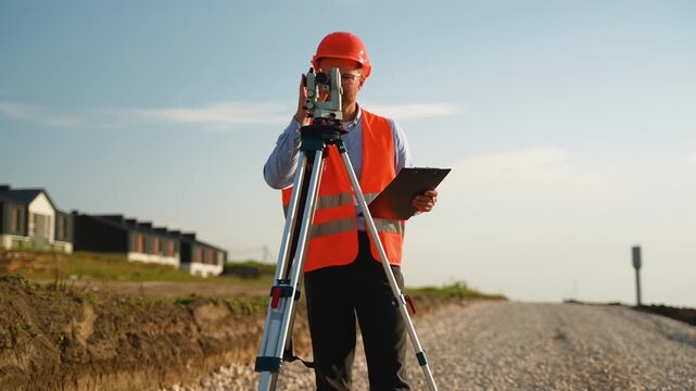 Surveyor engineer measuring land on construction site