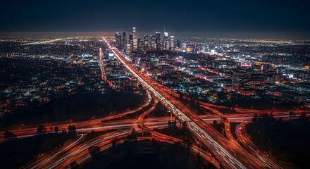 Fototapeta premium An impressive aerial night view of a bustling city highway interchange, with streaks of car lights illuminating the intricate network