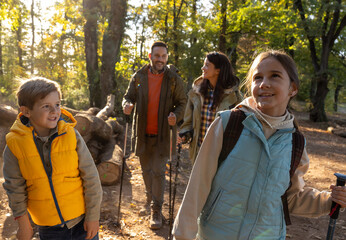 Family enjoys hiking together in a serene forest in autumn