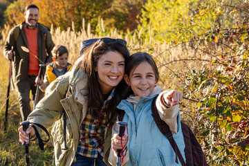 Family enjoys hiking together in a serene nature in autumn