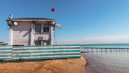 A wooden lifeguard station on the shore of a warm sea