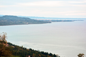 A breathtaking aerial view of a coastline bathed in pre-sunset light, where the golden hour transforms the landscape into a masterpiece of warm tones.