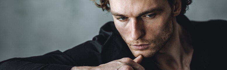 Banner. Black and white portrait of strong healthy elegant handsome sexy athletic man in casual clothing in a stylish loft interior, wearing suit, watches. Male model posing. Idea for groom's look