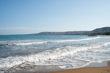 View over the Ionian Sea in Crotone in Calabria, Italy. In the background, a landscape of hills and mountains provides a natural, Mediterranean atmosphere. Clear sky and open space for easy text.