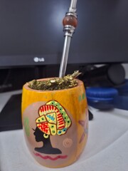 O item na imagem é, de fato, uma cuia (recipiente) contendo erva-mate, que é usada para preparar e beber o chimarrão (a bebida quente) ou, em algumas regiões, o tereré (a bebida fria), ambas muito pop