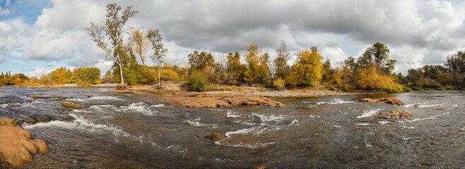 American River Clay Bank Rapids with Autumn Foliage under Dramatic Clouds