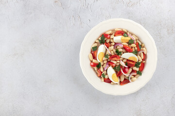  Turkish Piyaz high protein salad with white bean, tomatoes, eggs, parsley. Top view. Copy space. Turkish cuisine. 
