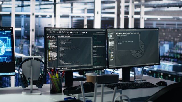 Server room PC screens tracking mainframes processing large scale machine learning datasets for artificial intelligence operations. Computer displays monitoring gear used in AI model development