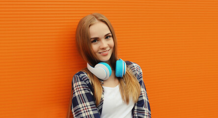 happy young woman listening to music with headphones, modern teenage girl in the city