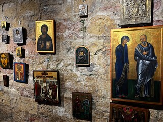 A wall of rough-hewn stone in Bentheim Castle adorned with a collection of framed religious icons (paintings and metal reliefs) in the style of Eastern Orthodoxy.