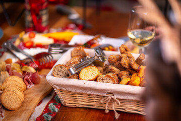 Delicious bread basket with crackers and charcuterie on a wooden table