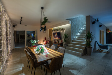 Festive dining room decorated for Christmas with a cozy fireplace and lights