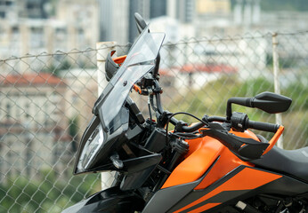 A view of a black and orange adventure motorcycle. Its various components and mechanisms are...