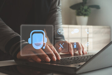 Modern customer support concept with a person typing on laptop and digital virtual interface showing headset and service icons, representing 24-7 online assistance, communication, technology support.