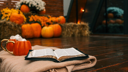 Autumn scene with pumpkins, mugs, marshmallows, and an open book
