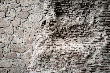 Old and weathered bricks abutting masonry in Rome, Italy
