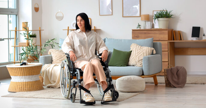 Beautiful young woman in wheelchair at home
