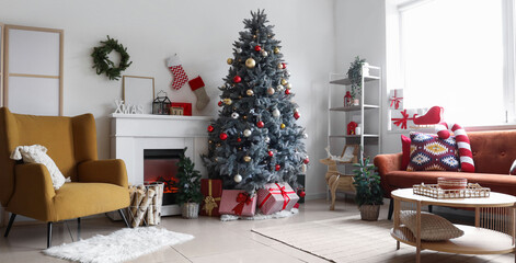 Interior of light living room with armchair, fireplace, Christmas tree and festive decorations