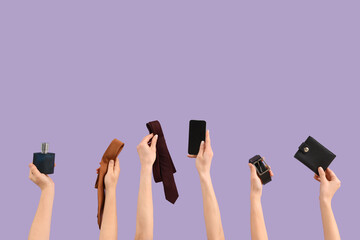 Young women holding belt, bottle of perfume, belt, wallet, mobile phone and men's ties on purple background