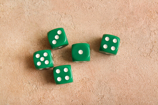 Green dices on beige background