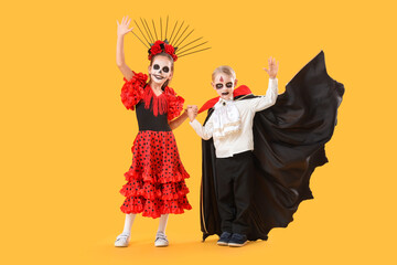Little children dressed for Halloween on yellow background