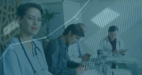 Healthcare team in medical attire reviewing data in hospital office, with stethoscopes and tablet