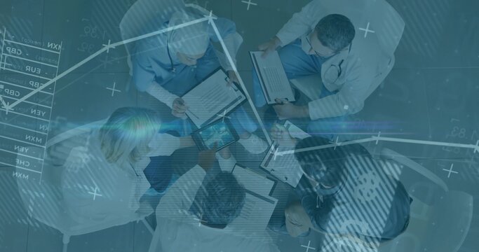 Five medical professionals reviewing patient data in hospital meeting with clipboards and tablet