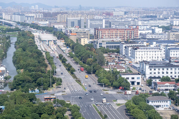 Aerial view of an industrial and residential district in Ningbo, Zhejiang China, featuring wide roads, factories, and apartment buildings. Urban planning, infrastructure and growing industrial economy