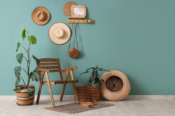 Interior of room with wooden chair, houseplants, wicker basket and shelf on blue wall