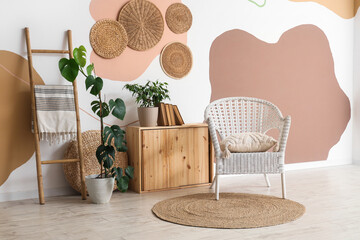Interior of room with wicker armchair, ladder and plants