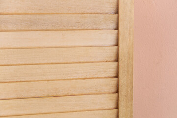 Texture of wooden folding screen on beige background, closeup