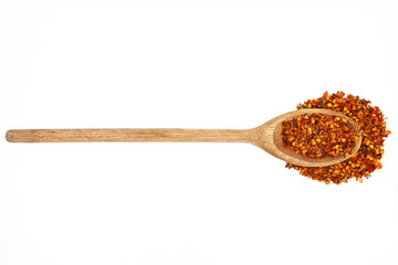 Wooden kitchen spoon filled with red chili powder isolated on white