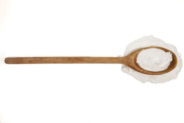 Wooden kitchen spoon filled with baking soda powder isolated on white
