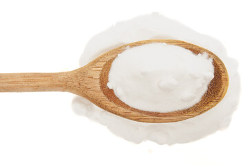Close-up of baking soda in rustic wooden spoon on white background